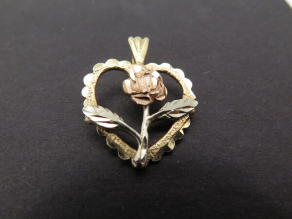 pendant of a rose inside a heart